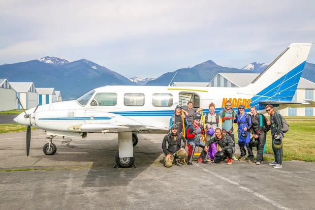 Skydivers celebrating a jumper's 100th airplane jump