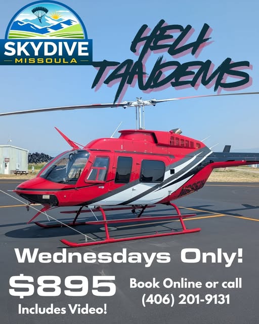 Red and white helicopter on the ramp, advertising Skydive Missoula helicopter tandems on Wednesdays
